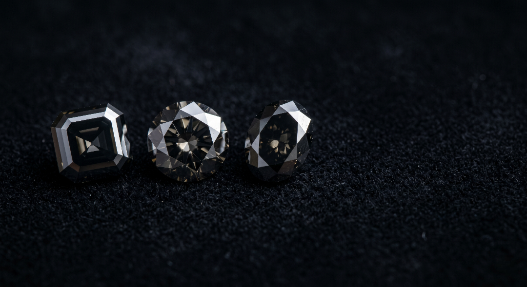 Three natural loose black diamonds in round, oval and asscher cuts on dark velvet for the complete buying guide
